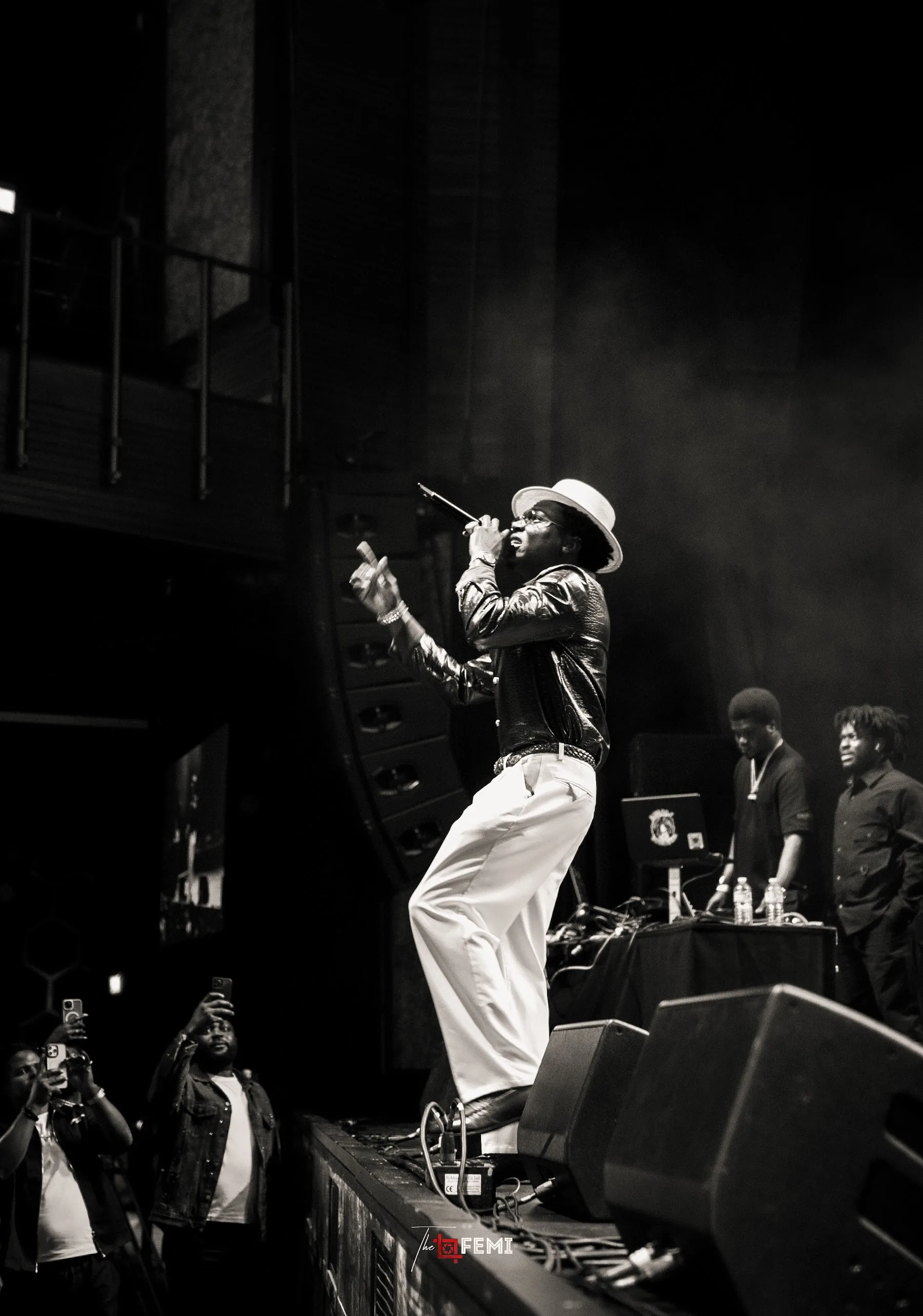 Performer on stage in black and white with the crowd below