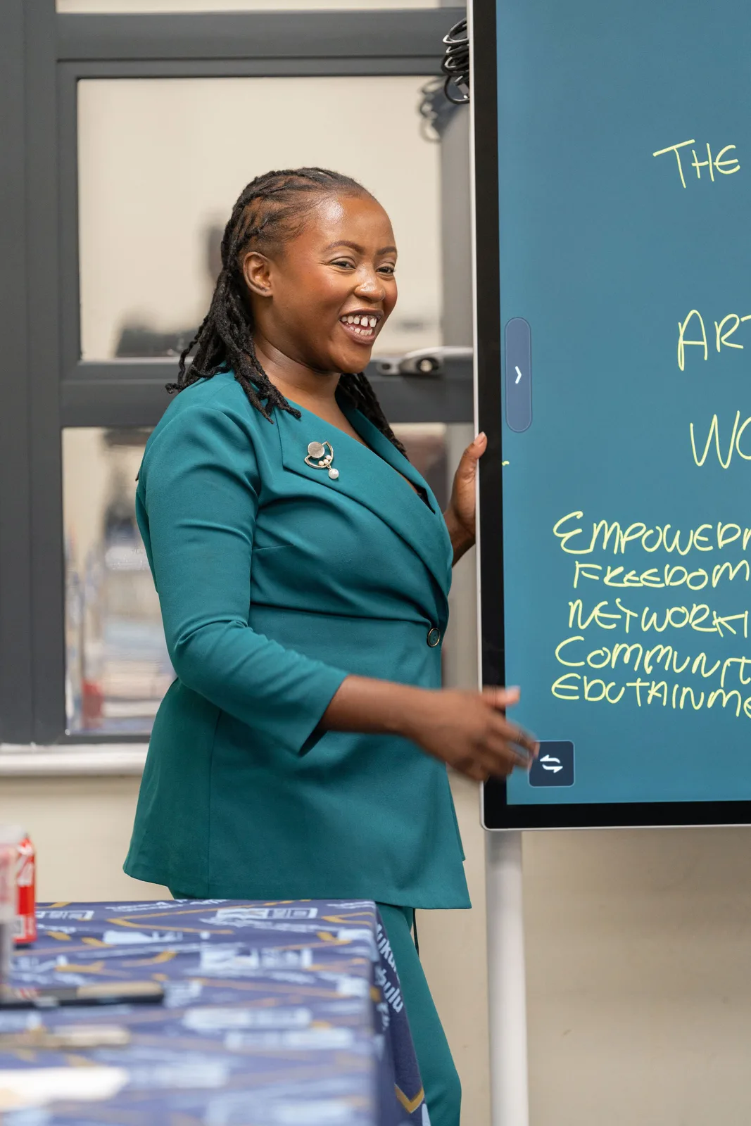Korrine Sky in a green suit working through the strategy on the whiteboard