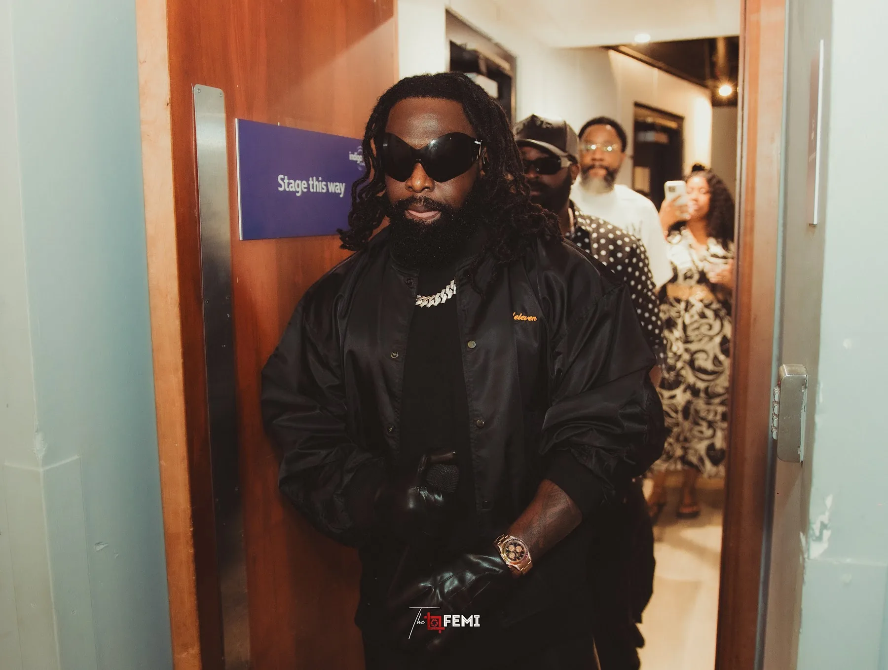Timaya walking through the backstage corridor towards the stage