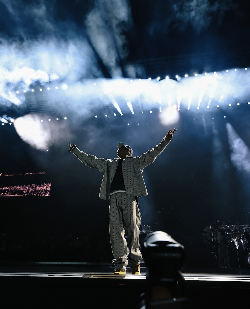 JAŸ-Z on stage at Yankee Stadium with both arms raised before the crowd
